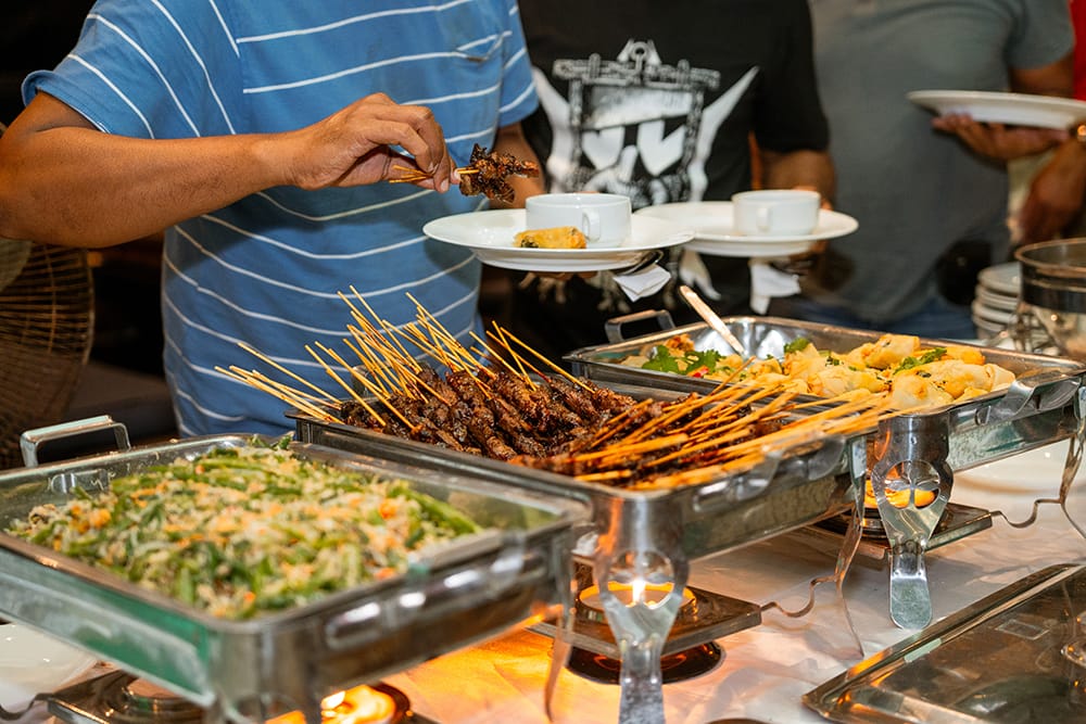 Guests enjoying satay and freshly prepared dishes at a Pavilion event
